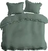 A bedding set with two pillows and a duvet cover, all in a mint green color and featuring ruffled edges. Produktbild-Vorschau