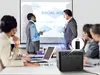 A business meeting where a projector is being used to display a presentation on a screen, with people in the foreground and background. Anteprima dell’immagine prodotto