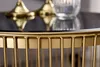 Close-up of a gold metal-framed round coffee table with a black glass top. Produktbild-Vorschau