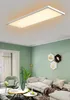 A modern living room with a green accent wall, featuring a large rectangular LED ceiling light. Produktbild-Vorschau