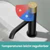 A black faucet with a gold handle is shown on a white sink. A graphic overlay indicates temperature control. Podgląd zdjęcia produktu