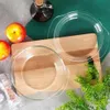 Two glass baking dishes are placed on a wooden cutting board, with apples, a salt grinder, and greenery in the background. Podgląd zdjęcia produktu