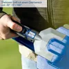 A person is holding a blue and gray garden tool, possibly a hedge trimmer, with a close-up view of the handle and part of the blade. Produktbild-Vorschau