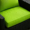 A close-up view of a green cushion on a black wicker chair, with water droplets on the cushion. Anteprima dell’immagine prodotto
