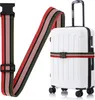 A white suitcase with a colorful luggage strap wrapped around it. Náhled obrázku produktu