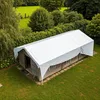 An aerial view of a wooden structure covered by a white tarp, situated in a grassy area surrounded by trees. Produktbild-Vorschau