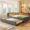 A modern bedroom with a grey upholstered bed frame featuring integrated LED lighting and a pull-out trundle bed. Produktbild-Vorschau