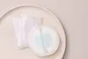 A close-up shot of disposable nursing pads on a light wooden tray. Produktbild-Vorschau