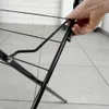 A hand is shown adjusting a black metal drying rack. Náhľad obrázku produktu
