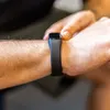 A person's wrist wearing a black fitness tracker. Produktbild-Vorschau