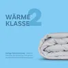 A folded white duvet is shown against a light blue background with text indicating its warmth class. Podgląd zdjęcia produktu