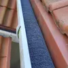 A close-up view of a gutter with a dark gray foam filter installed. Anteprima dell’immagine prodotto