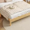 A close-up view of a wooden bed frame with bedding. Produktbild-Vorschau