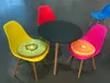 A small round table with four colorful chairs around it, each with a fruit-themed cushion. Produktbild-Vorschau