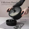 A person is pouring water from a pot with noodles into a bowl. Anteprima dell’immagine prodotto