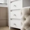 Close-up of white drawers with crystal knobs, part of a vanity or dresser. Produktbild-Vorschau