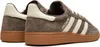 A close-up side view of a pair of brown Adidas sneakers with white stripes and a gum sole. Voir les images du produit