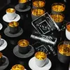 A collection of espresso cups and saucers with gold interiors, arranged on a black surface. Náhled obrázku produktu