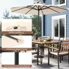An outdoor patio scene with a table, chairs, and a large umbrella. Podgląd zdjęcia produktu
