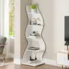A white wave-shaped corner shelf unit filled with decorative items and books. Podgląd zdjęcia produktu