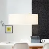 A dining table with chairs, a tablet, and a glass of water, under a decorative pendant light. Produktbild-Vorschau