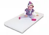 A baby sitting on a white mattress. Produktbild-Vorschau