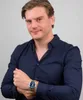 A man wearing a dark blue shirt and a watch. Anteprima dell’immagine prodotto