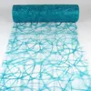 A roll of decorative fabric with a circular pattern, unrolled on a white surface. Produktbild-Vorschau
