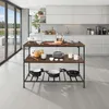 A modern kitchen with a kitchen island in the foreground, featuring cookware and dishes. Large glass doors open to an outdoor area with a pool. Voir les images du produit