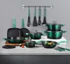 A collection of cookware and kitchen utensils arranged on a countertop against a gray wall. Produktbild-Vorschau