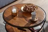 Couchtisch Sheesham mit runder Holzplatte und schwarzem Metallrahmen, Gesamtansicht von oben mit Dekoration. Voir les images du produit