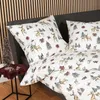 A close-up view of bedding with a Christmas-themed pattern of deer and trees. Produktbild-Vorschau