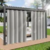 Outdoor curtains hanging from a pergola on a wooden deck, with a lawn and house in the background. Produktbild-Vorschau