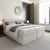 A modern bedroom with a large beige upholstered box spring bed. Produktbild-Vorschau