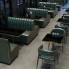 A restaurant or cafe interior with green booth seating and tables. Anteprima dell’immagine prodotto