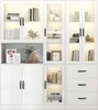 A white display cabinet with glass doors and drawers, filled with decorative items and books. Podgląd zdjęcia produktu