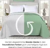 A bed with a reversible comforter, shown in two colors. Produktbild-Vorschau