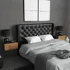 A bedroom scene featuring a bed with a tufted headboard, nightstands, lamps, and artwork on the wall. Produktbild-Vorschau