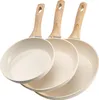 Three beige frying pans with wooden handles are arranged in a staggered formation against a white background. Náhľad obrázku produktu