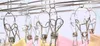 A close-up view of stainless steel clothes clips hanging on a drying rack, with some fabric items clipped to them. Produktbild-Vorschau
