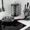 A kitchen corner with cooking utensils, a spice rack, a knife block, and a frying pan on a stovetop. Anteprima dell’immagine prodotto
