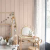 A child's bedroom with a wooden bed frame, decorative lights, a rattan vanity table with a mirror, and a chair. Anteprima dell’immagine prodotto