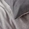 A close-up view of textured bedding in two shades of gray. Produktbild-Vorschau