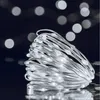 A close-up of a coiled string of white LED lights with a dark, bokeh background. Produktbild-Vorschau