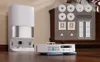 A robotic vacuum cleaner and its accessories are displayed on a wooden floor, with a charging station in the background. Produktbild-Vorschau