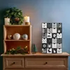 A Christmas-themed scene featuring an advent calendar, a wreath, candles, and decorative ornaments on a wooden dresser. Náhled obrázku produktu