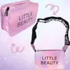 A collage of two pink iridescent cosmetic bags with the text 'LITTLE BEAUTY' on them, set against a pastel background with decorative swirls. Produktbild-Vorschau