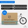 A bicycle is partially visible next to a cardboard box with branding and product information. Produktbild-Vorschau