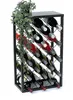 A black metal wine rack filled with wine bottles, with a green artificial plant draped over the top left corner. The rack is set against a white background. Produktbild-Vorschau