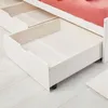 Close-up view of the open drawers of a white wooden bed frame. Produktbild-Vorschau